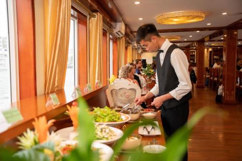 下龍灣的住宿－Dragon Crown Legend Cruise，一个人在自助餐中准备食物
