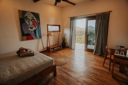 a bedroom with a bed with a painting on the wall at Disini Lombok ECO Sky House with Sea view in Selong Belanak