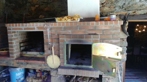 a brick fireplace with an open door with at Casa Da Pena in Góis