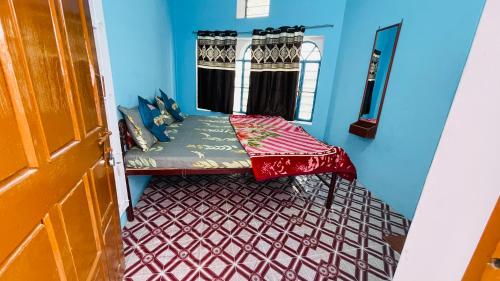 Habitación pequeña con cama y ventana en Mayur Guest House, en Pushkar