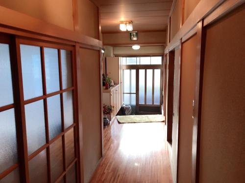 an empty hallway with a door leading to a room at 花源 in Beppu