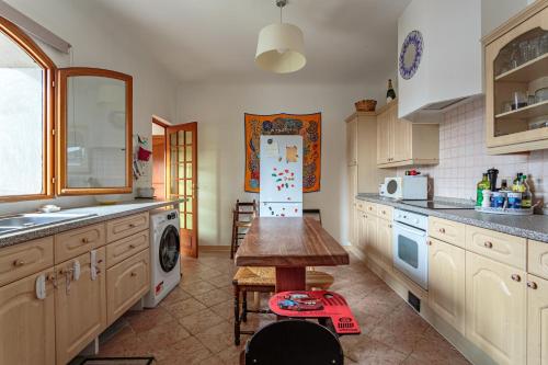 a kitchen with a refrigerator and a table in it at Villa Les Lys - Avec piscine et grand jardin in Sames