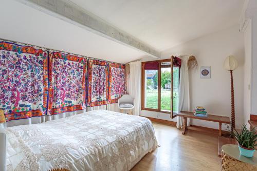 a bedroom with a large bed and colorful curtains at Villa Les Lys - Avec piscine et grand jardin in Sames