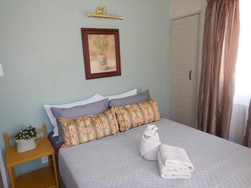 een slaapkamer met een bed met twee handdoeken erop bij Solitaire Guest Apartments in Pretoria