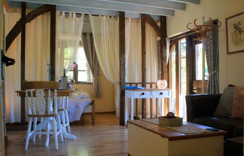 a living room with a couch and a table at The Nest - Thatched seaside country cottage for two in Stokeinteignhead