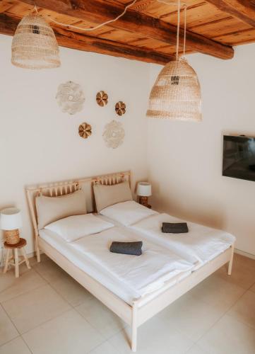 a white bed in a white room with two lights at Ako doma in Poltár