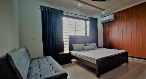 ein Schlafzimmer mit einem Bett, einem Stuhl und einem Fenster in der Unterkunft Bed and Breakfast 430 in Islamabad