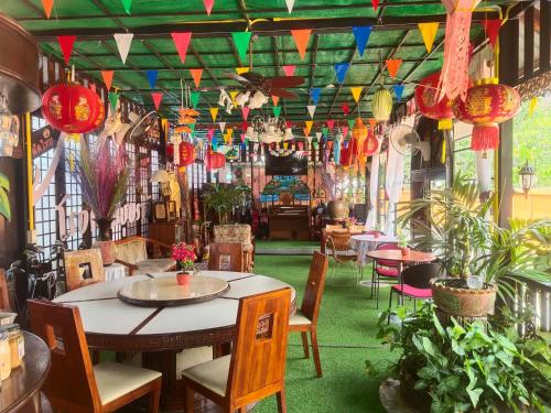 un restaurante con mesa, sillas y banderas coloridas en Bussaracum Resort, en Kanchanaburi