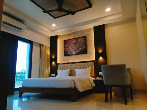a bedroom with a bed and a desk and a chair at Sambhabana Hotel & Suites in Tarapith