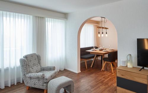 a living room with a table and a chair and a dining room at Residence Eden in Arosa