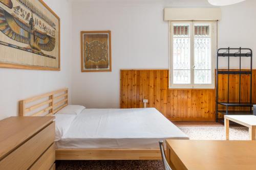 Schlafzimmer mit einem Bett, einem Schreibtisch und einem Fenster in der Unterkunft Sant'Orsola Apartment by Wonderful Italy in Bologna