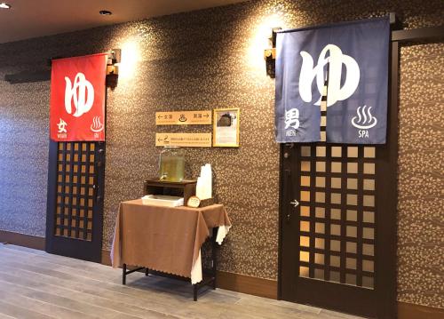 a room with a table and two signs on the wall at TABINO HOTEL Hida Takayama in Takayama