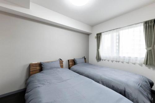 a bedroom with two beds next to a window at STELLAR in Ōdōri