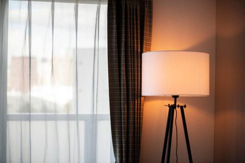 a lamp sitting next to a window with a curtain at STELLAR in Ōdōri