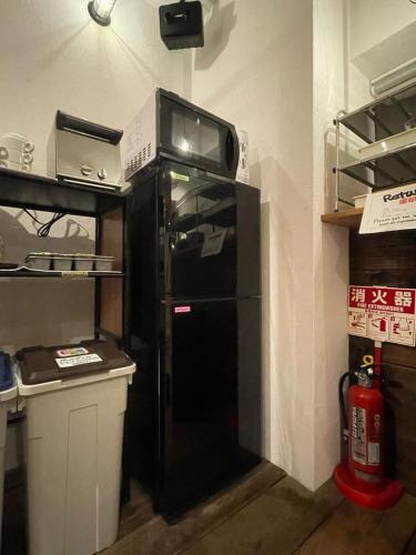 a black refrigerator with a microwave on top of it at GuestHouse Shirakawa-Go INN in Shirakawa