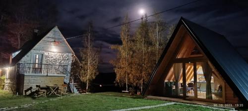 a cabin at night with the moon in the sky at Mountain inn in Žabljak