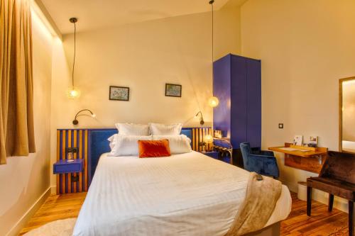 1 dormitorio con 1 cama blanca grande y escritorio en Le Castel Cabourg hôtel & SPA- Restaurant La Calypso en Cabourg