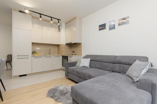 un soggiorno con divano e una cucina di Goodnight Apartments Białołęka with 2 Bedrooms & Parking by Renters a Varsavia