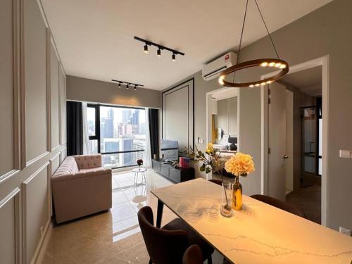 a kitchen and living room with a table and chairs at Axon Serviced Suites Kuala Lumpur in Kuala Lumpur
