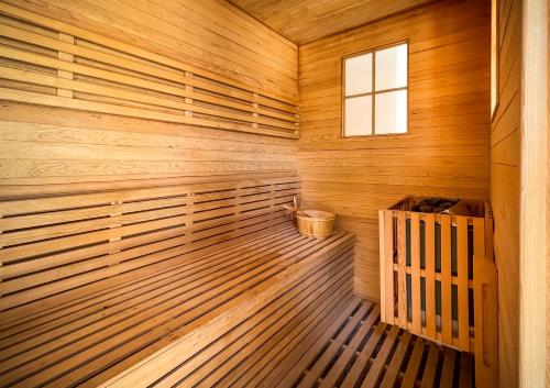 a sauna with wooden walls and a window at Souq Al Wakra Hotel Qatar By Tivoli in Doha