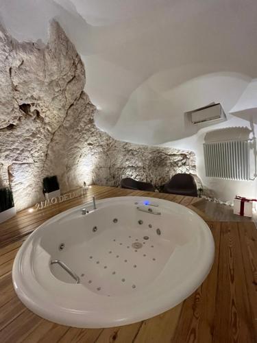 una vasca da bagno in una stanza con parete di roccia di 21mq Suite Homes Ostuni a Ostuni