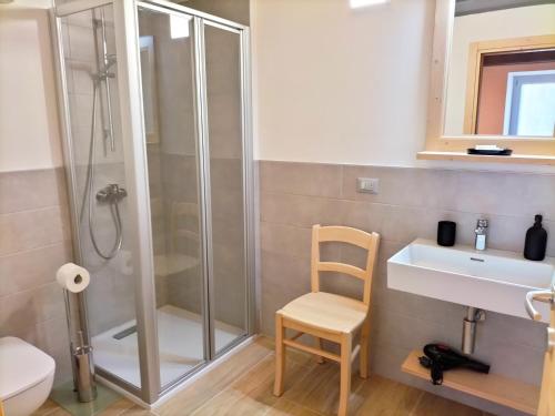 a bathroom with a shower and a sink and a chair at Cà Soldati in Campi