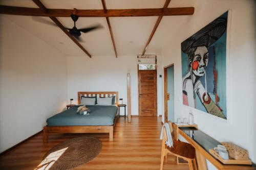 ein Schlafzimmer mit einem Bett und einem Wandgemälde in der Unterkunft Disini Lombok ECO Sky House, Selong Belanak in Selong Belanak