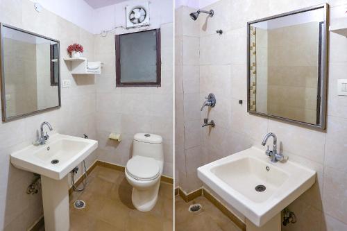 een badkamer met een wastafel, een toilet en een spiegel bij THE EDEN HOTEL Near Okhla in New Delhi