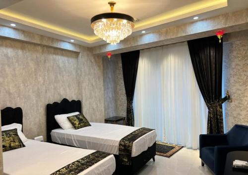 a hotel room with two beds and a chandelier at sutluce's luxury suite with a golden horn view in Istanbul