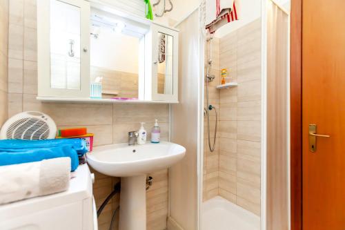 a small bathroom with a sink and a shower at Lucrezia Cinecittà House in Rome