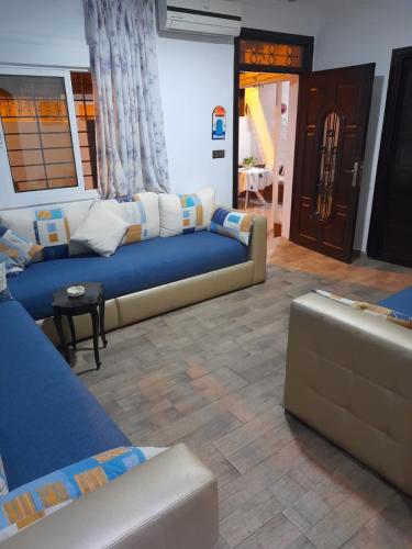 a living room with two couches and a table at Lovely house with garden in Martil