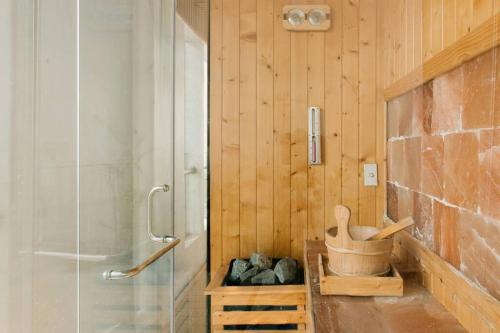 baño con paredes de madera y ducha con lavamanos en Luxury Penthouse 240m2, 3Br, Quận2, en Ho Chi Minh