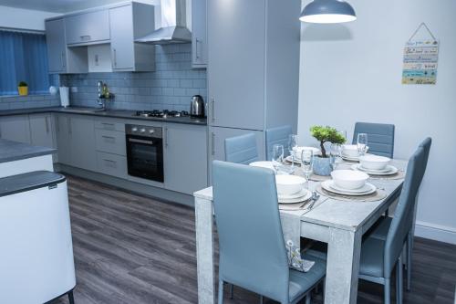 a kitchen with a dining table with chairs and a table at Lush Lodge -Home away in Telford, For Contractors, families, group of friends, Long Term Stays in Telford