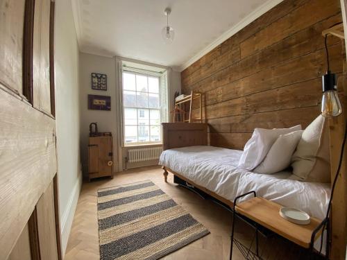 ein Schlafzimmer mit einem Bett und einer Holzwand in der Unterkunft Georgian Townhouse in Brecon