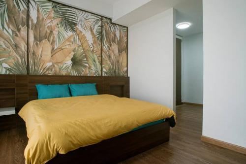 Un dormitorio con una cama amarilla con una pintura en la pared en Luxury Penthouse 240m2, 3Br, Quận2, en Ho Chi Minh