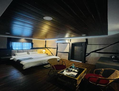 1 dormitorio con 1 cama, mesa y sillas en Daosri The Inn, en Jyoti Gaon