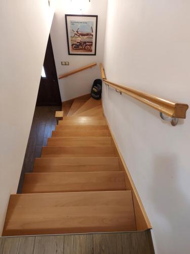 a staircase with wooden floors and a rail at Titi Boutique Apartmanok in Bükfürdő