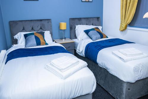 twee bedden naast elkaar in een slaapkamer bij Lush Lodge -Home away in Telford in Telford