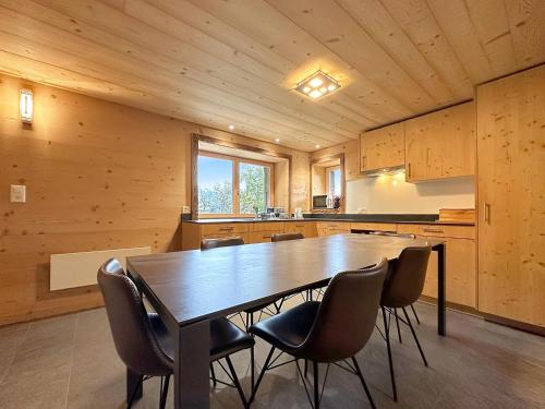une cuisine avec une grande table et des chaises en bois dans l'établissement Chalet a Didi - Alps Paradise - 4 Vallees, à La Tzoumaz