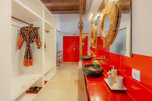 un bagno con pareti rosse e un bancone rosso di Bali Ginger Suites & Villa a Seminyak