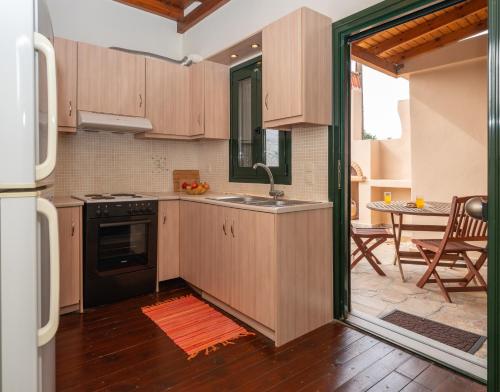 a kitchen with wooden cabinets and an open door at Ornus Traditional House in Orné