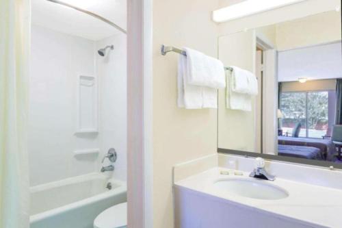 La salle de bains blanche est pourvue d'un lavabo et d'un miroir. dans l'établissement Ashland Studio Inn By OYO Richmond North near Kings Dominion, à Ashland