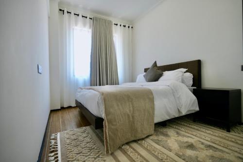 a bedroom with a large bed and a window at An Oasis in the heart of Kigali in Kigali
