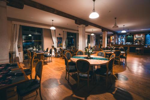 a restaurant with tables and chairs in a room at Romantic Hotel Mlýn Karlstejn in Karlštejn