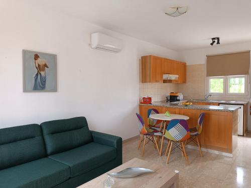 uma sala de estar com um sofá, uma mesa e uma cozinha em Aphrodite Hills Adonis Apartment em Kouklia
