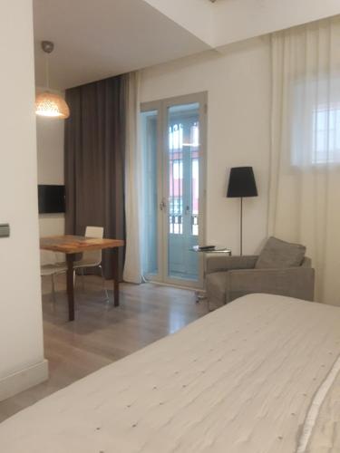 a room with a bed and a couch and a table at Las Coles Apartasuites in Xàtiva