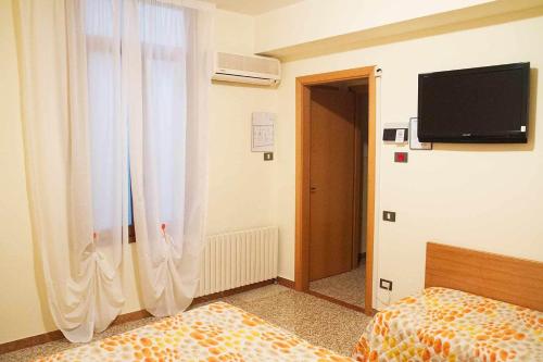 a bedroom with a bed and a television on the wall at Albergo Dal Baffo in Lazise