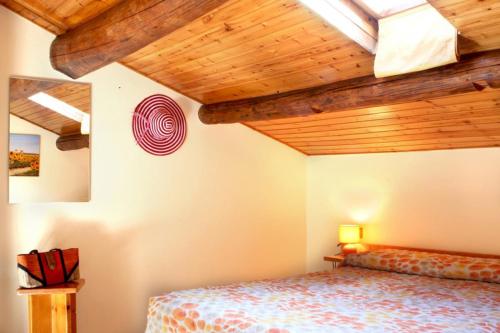 una camera con letto e soffitto in legno di Albergo Dal Baffo a Lazise