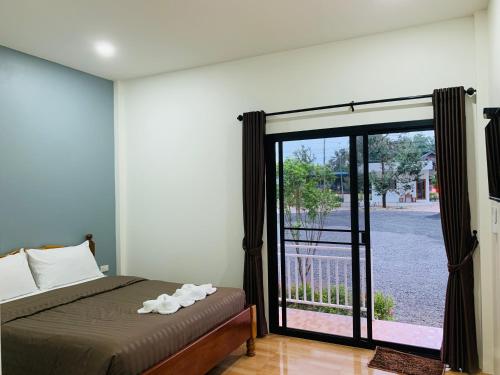 a bedroom with a bed and a sliding glass door at Suanvadee Resort สวนวดี รีสอร์ท in Don Sak