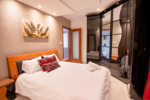 a bedroom with a white bed with red pillows at Stylish Corner Maisonette - Sunflower in Birkirkara